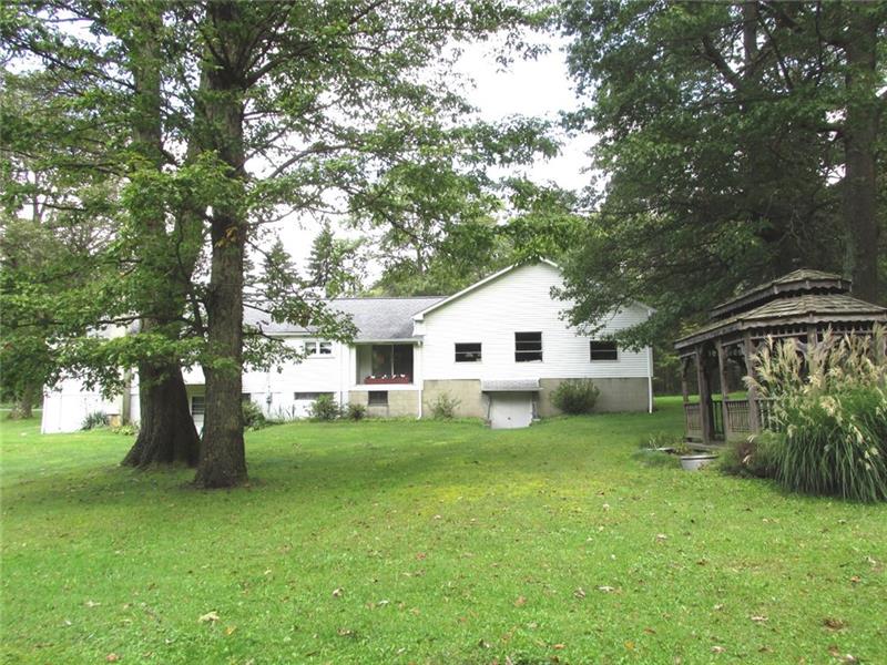 380 Dillon Road Acme, PA 15610 - Photo 20 of 25 Back of home. The 3 windows on the right are all in the garage. You can see that there is double work a double work door to get your maintenance equipment in and out. Off to the right is back yard gazebo.