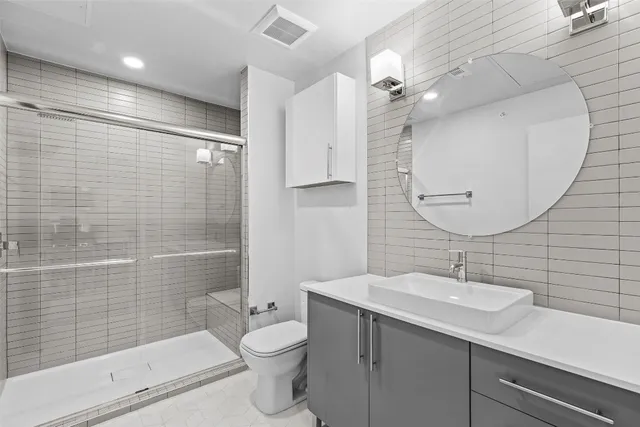 a bathroom with a sink a toilet and shower