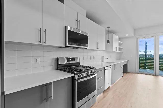 a kitchen with stainless steel appliances a stove a sink and a microwave