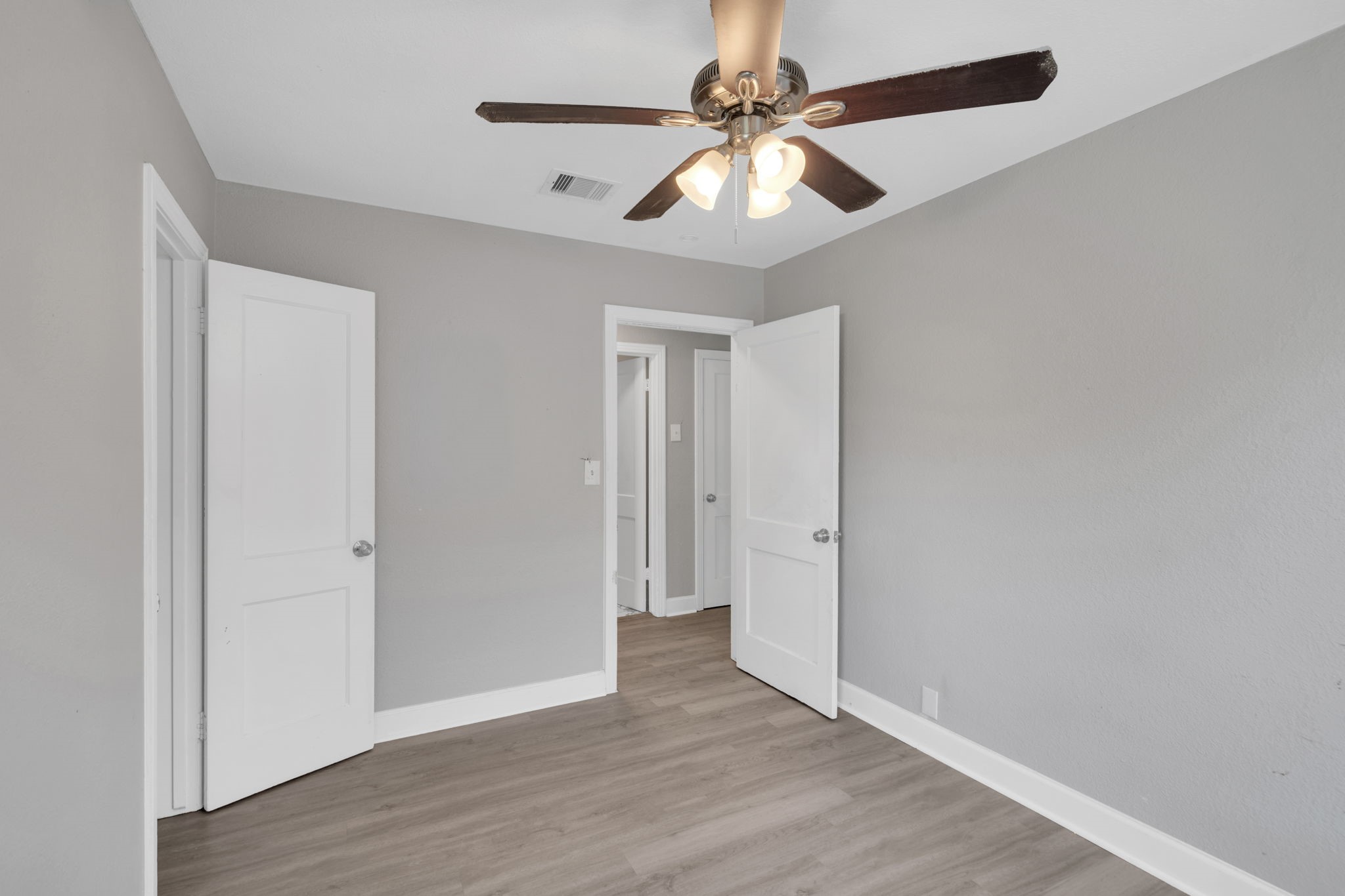 12358 Mylla Street Houston, TX 77015 - Photo 12 of 17 an empty room with wooden floor and ceiling fan