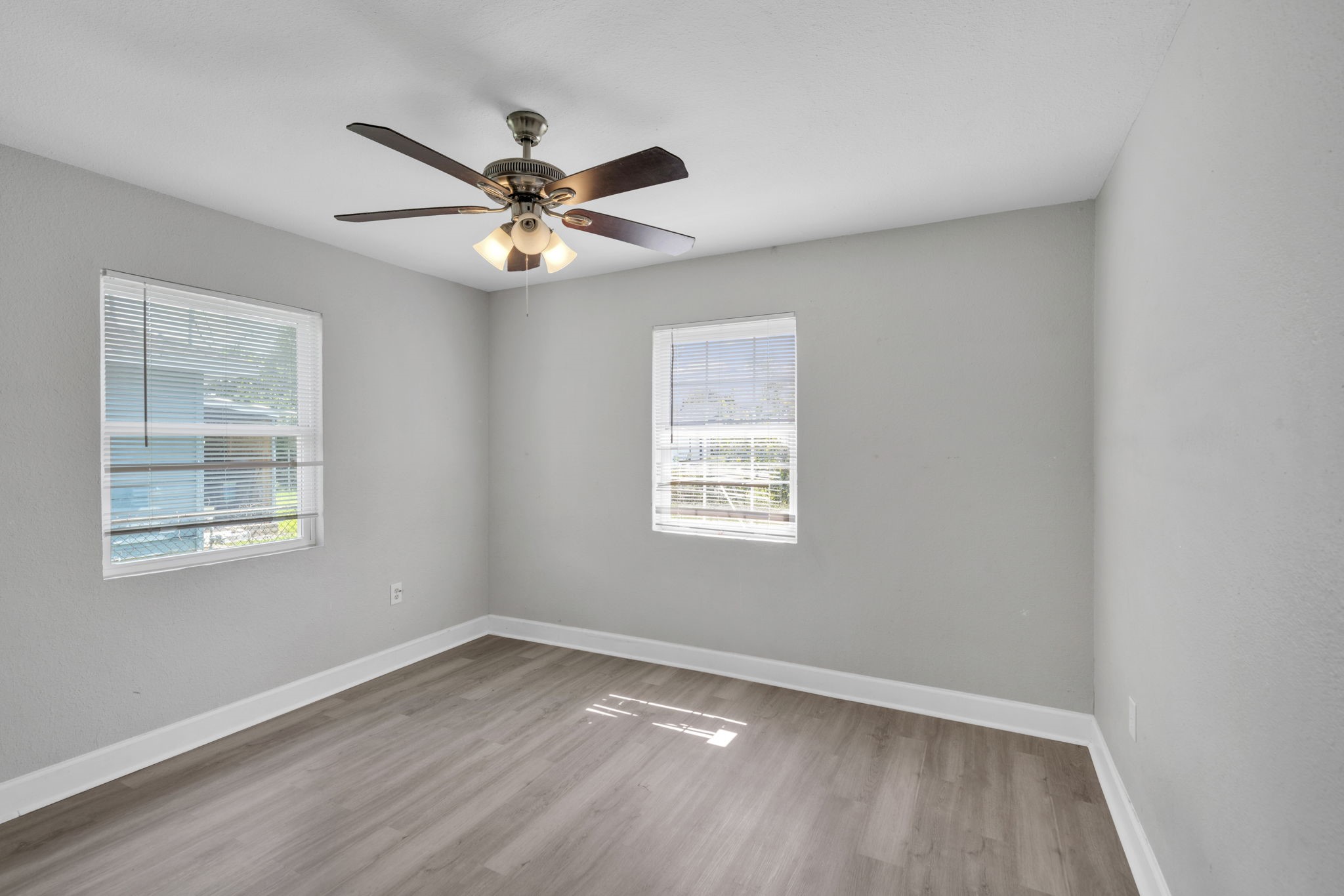 12358 Mylla Street Houston, TX 77015 - Photo 13 of 17 an empty room with wooden floor fan and windows