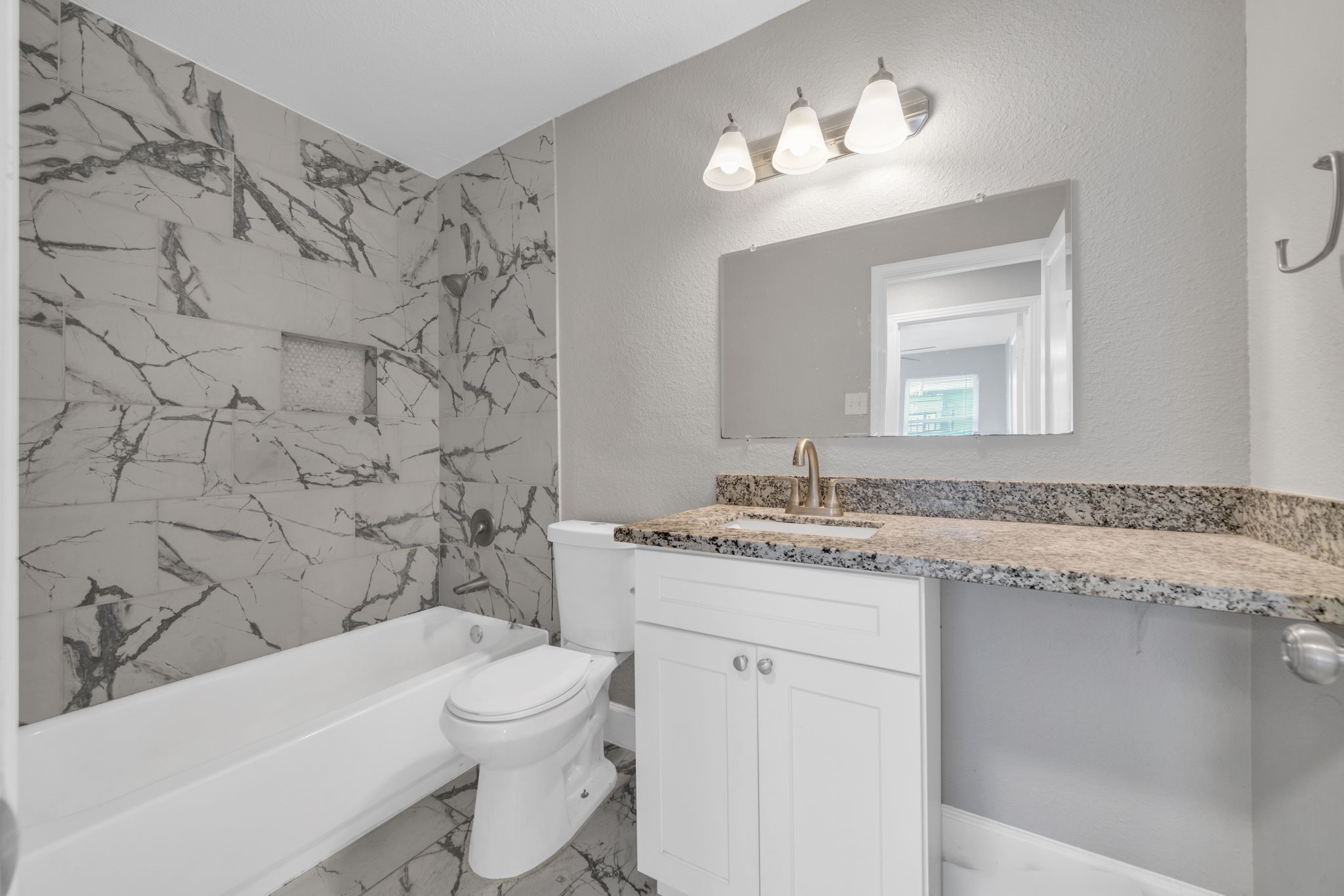 12358 Mylla Street Houston, TX 77015 - Photo 14 of 17 a bathroom with a granite countertop sink a toilet and a bathtub