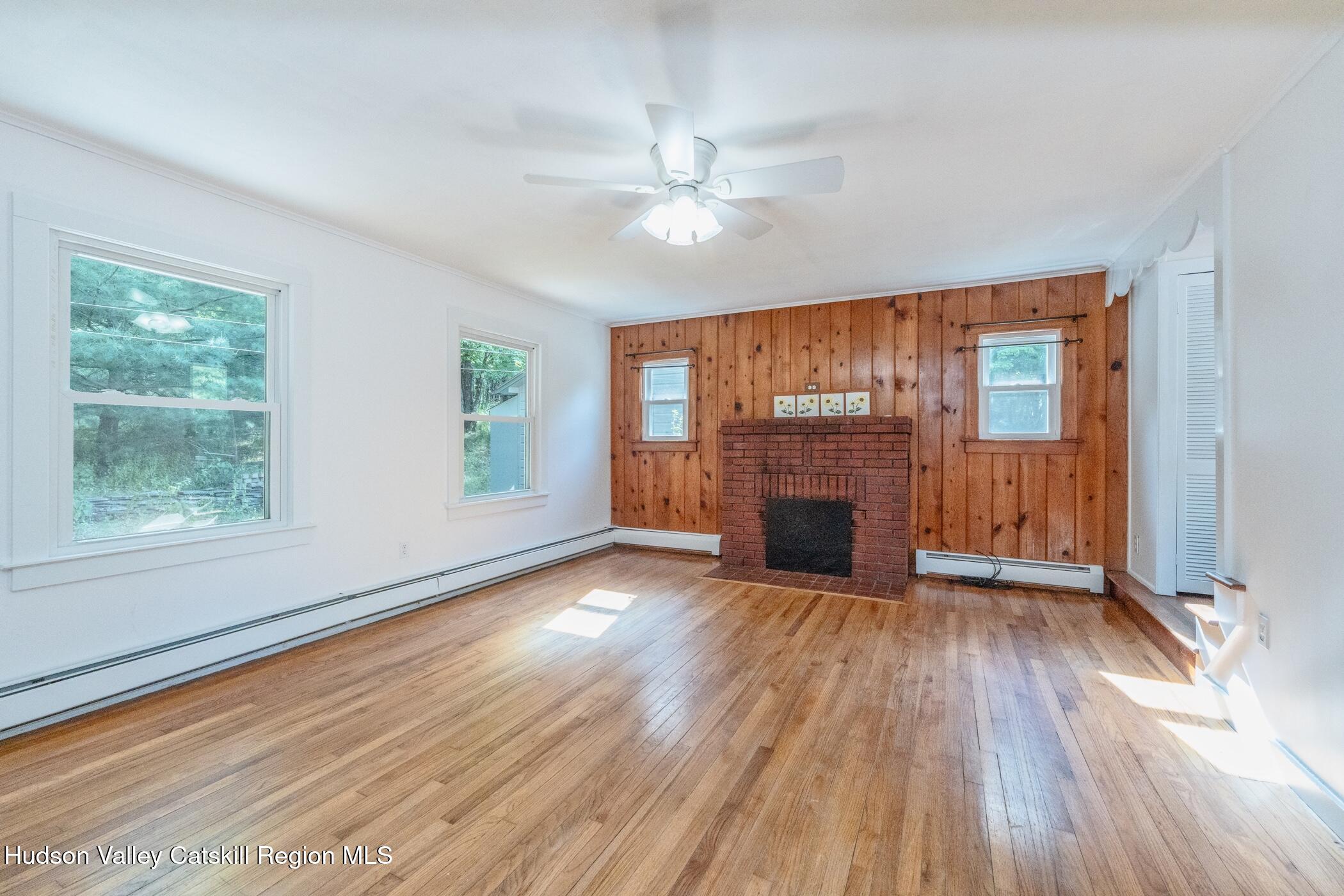 4533 Atwood Road Stone Ridge, NY 12484 - Photo 9 of 63 wooden floor fireplace and windows in an empty room