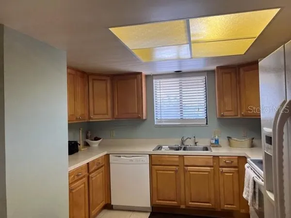 a kitchen with granite countertop a sink stainless steel appliances cabinets and a window