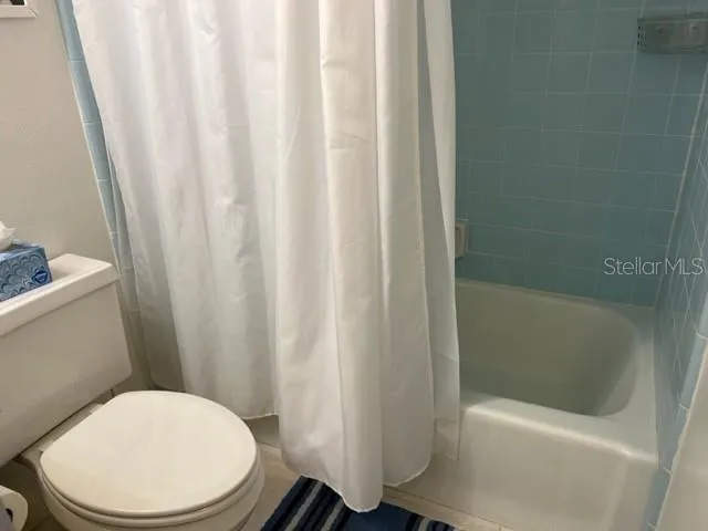 a white toilet sitting next to a bathtub