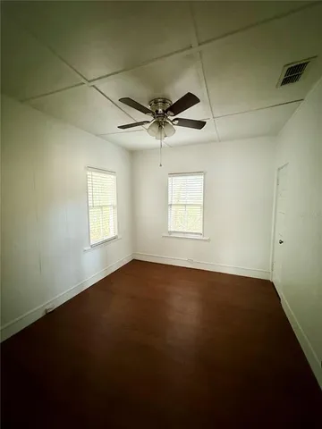 an empty room with a window and a ceiling fan