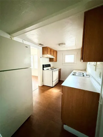 a kitchen with stainless steel appliances a sink cabinets and a wooden floor