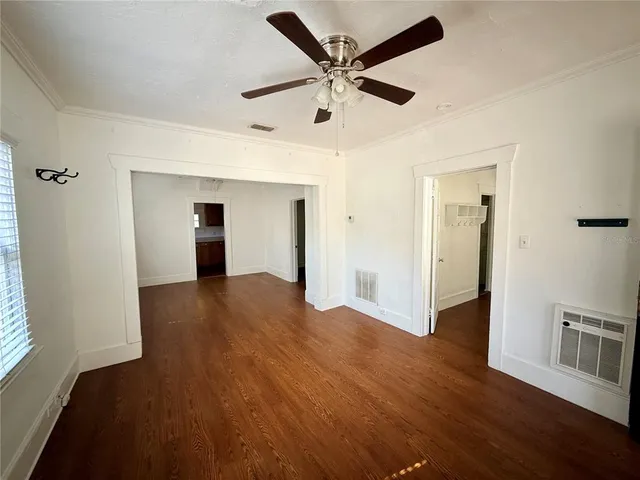 a view of a livingroom with wooden floor and a ceiling fan