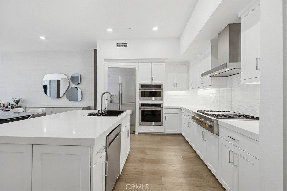 1604 Rivington Irvine, CA 92612 - Photo 19 of 75 a kitchen with kitchen island a sink stove top oven and cabinets