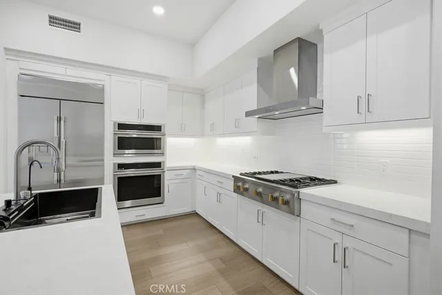 a kitchen with granite countertop a sink stove and refrigerator