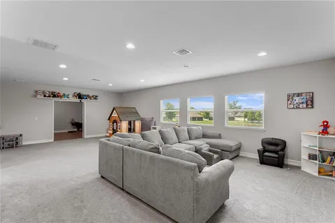a living room with furniture and a ceiling fan