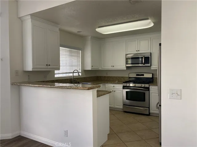 a kitchen with granite countertop a sink and a stove top oven