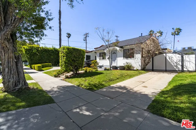 a view of a house with a yard and potted plants