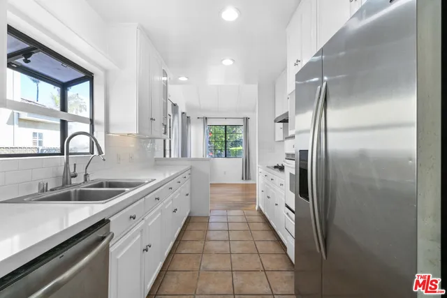 a large kitchen with a large window and stainless steel appliances