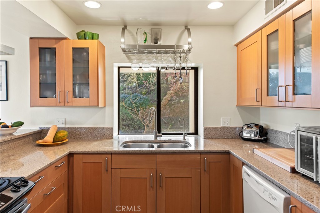8255 Balboa Road Atascadero, CA 93422 - Photo 23 of 72 a kitchen with stainless steel appliances a sink a stove and a wooden cabinets