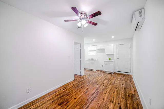 a view of a livingroom with a ceiling fan and wooden floor