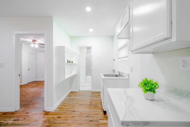 a hallway with wooden floor and chandelier