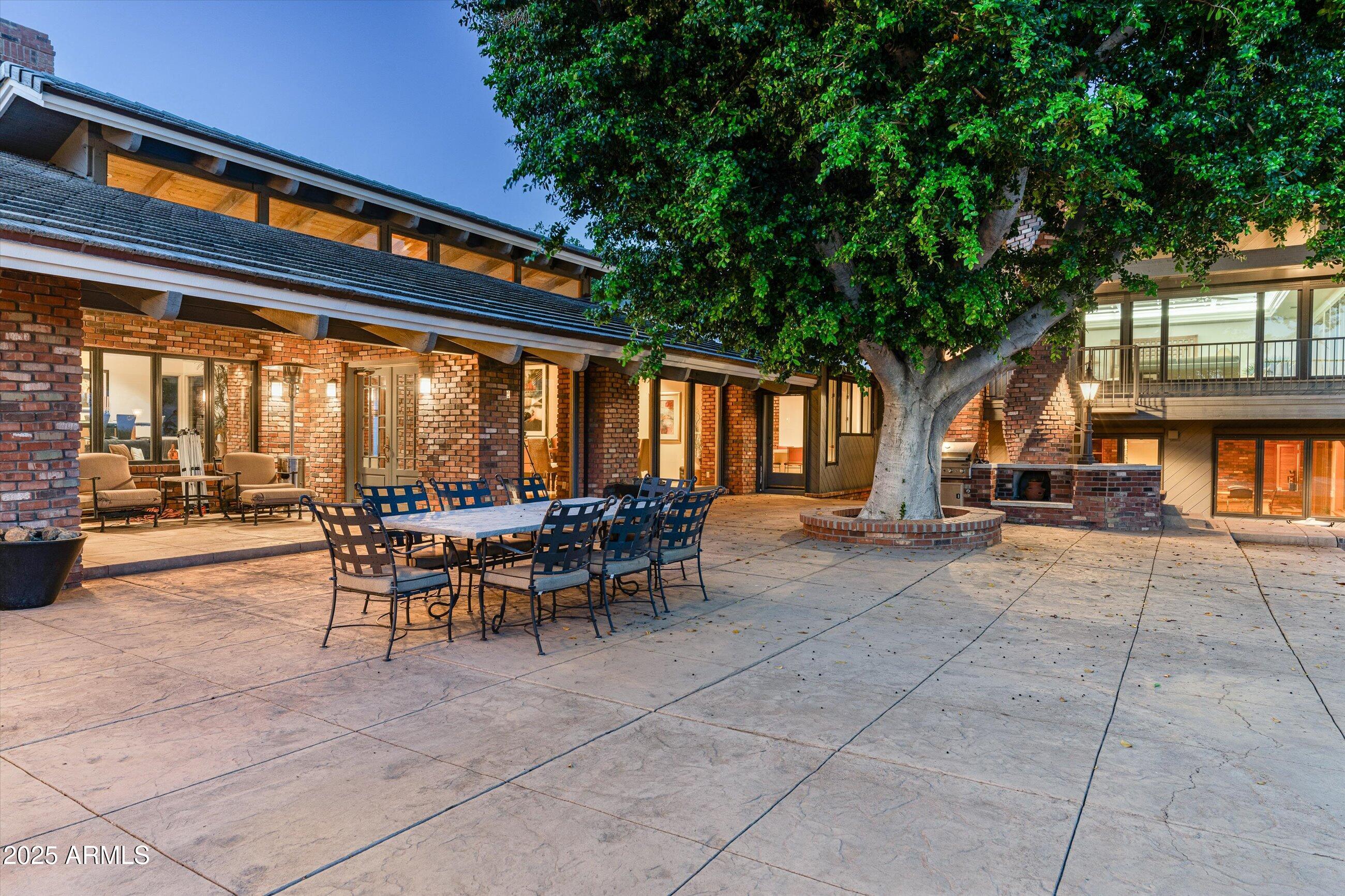 6830 North 46th Place Paradise Valley, AZ 85253 - Photo 3 of 65 a view of a patio with table and chairs and floor to ceiling window