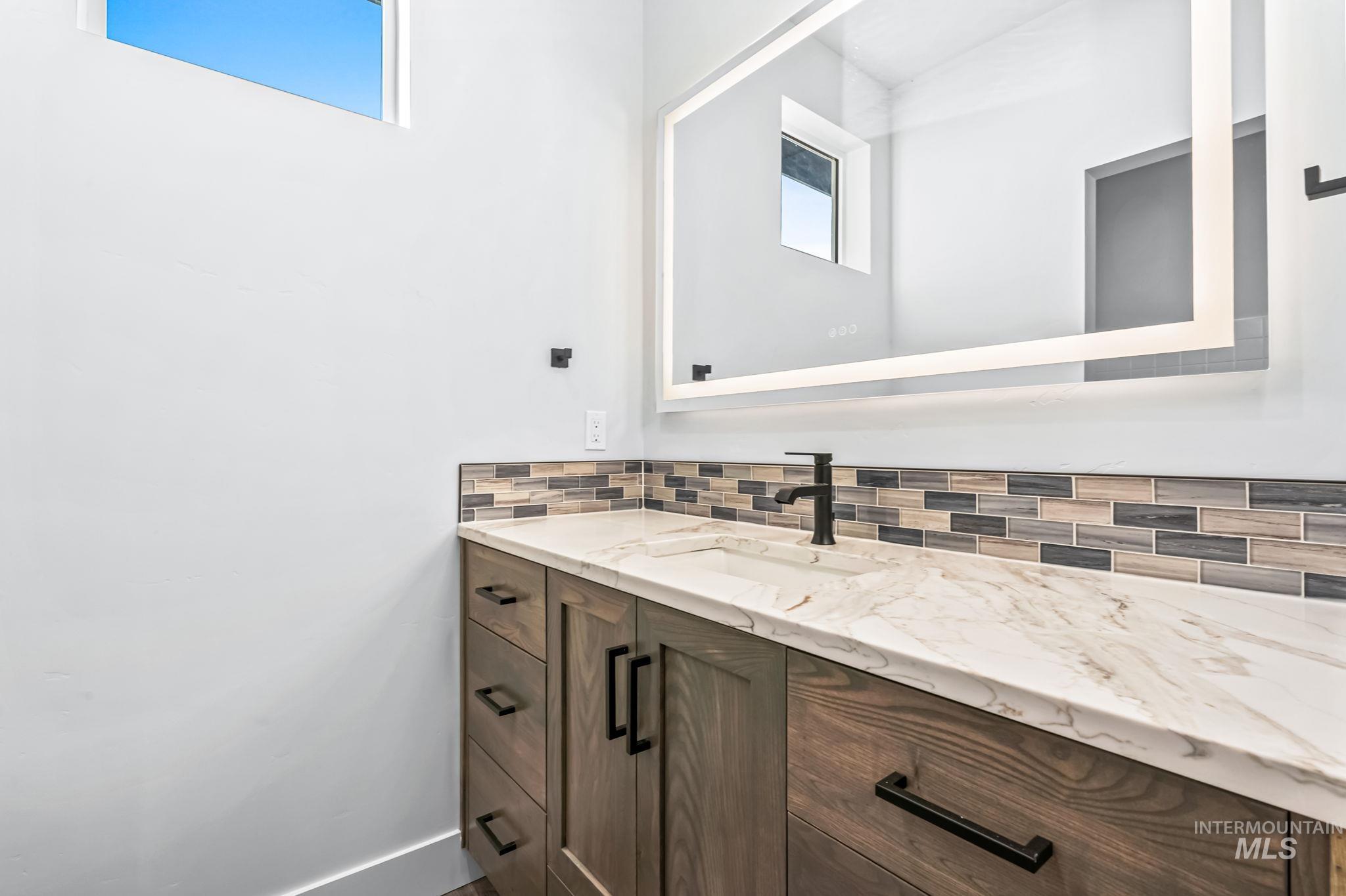 2905 Cypress Point Payette, ID 83661 - Photo 13 of 26 Bathroom featuring vanity and decorative backsplash