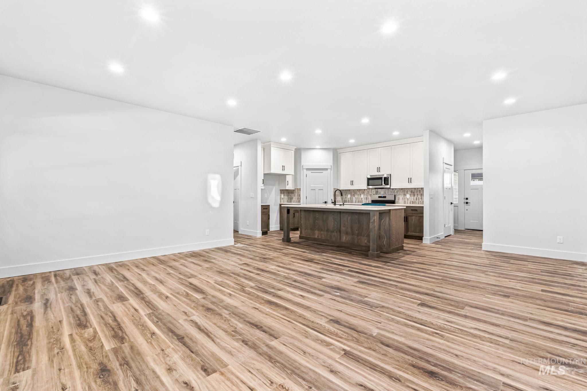 2905 Cypress Point Payette, ID 83661 - Photo 25 of 26 Kitchen featuring open floor plan, a kitchen island with sink, light countertops, white cabinets, and recessed lighting