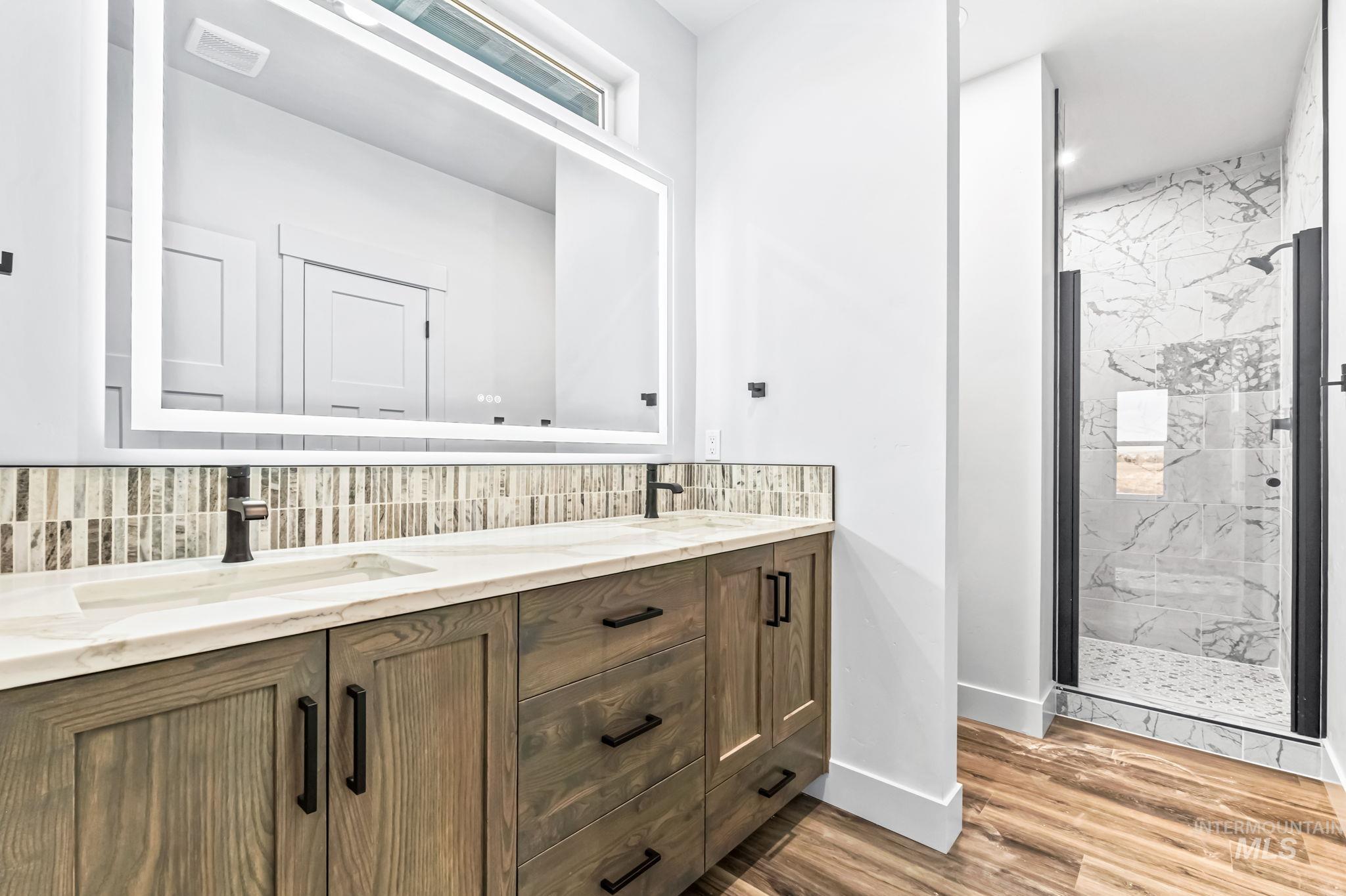 2905 Cypress Point Payette, ID 83661 - Photo 7 of 26 Full bathroom featuring double vanity, a marble finish shower, tasteful backsplash, and light wood-style flooring