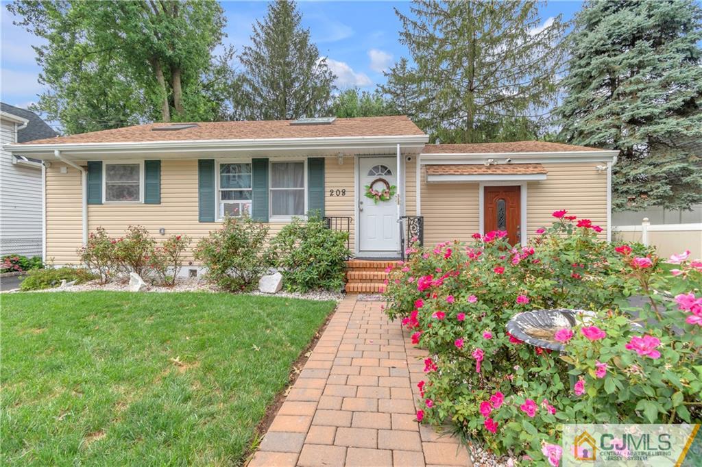 208 Oak Place Piscataway, NJ 08854 - Photo 1 of 23 a front view of a house with a porch and garden