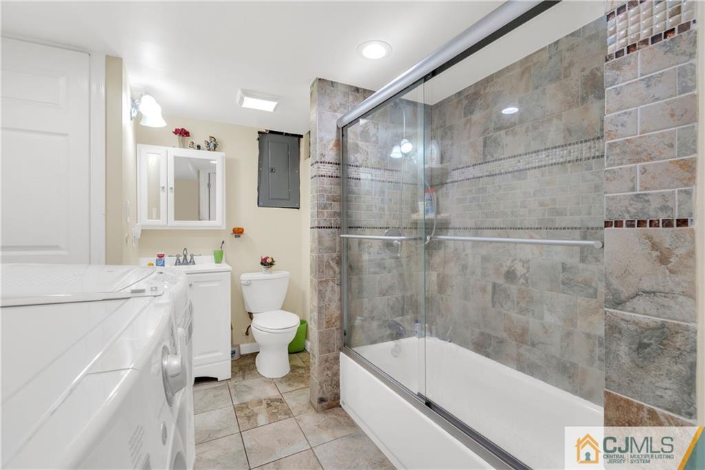 208 Oak Place Piscataway, NJ 08854 - Photo 15 of 23 a bathroom with a white bath tub a toilet and a shower