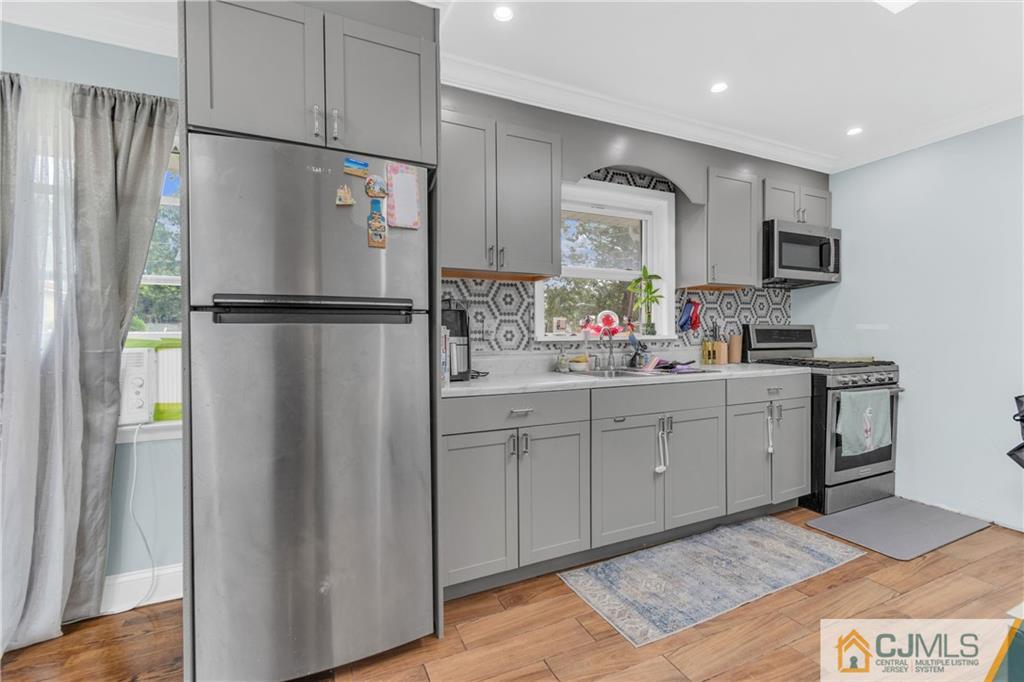 208 Oak Place Piscataway, NJ 08854 - Photo 5 of 23 a kitchen with a refrigerator sink and cabinets