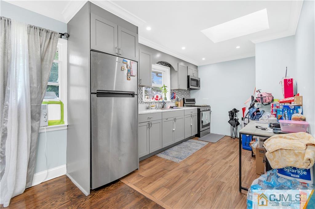 208 Oak Place Piscataway, NJ 08854 - Photo 6 of 23 a kitchen with stainless steel appliances a refrigerator sink and wooden floor