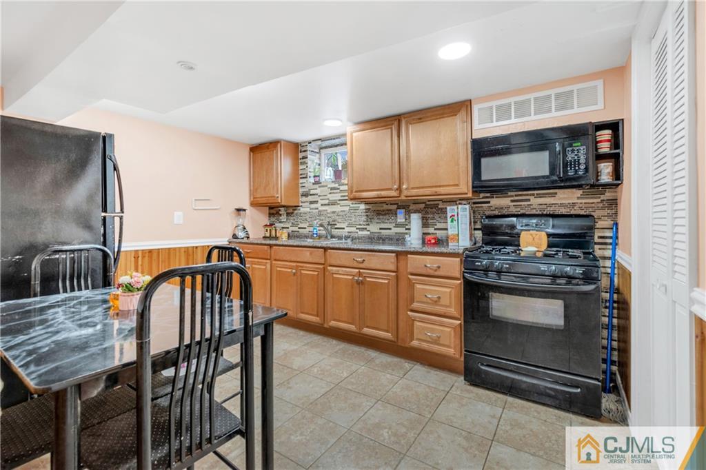 208 Oak Place Piscataway, NJ 08854 - Photo 10 of 23 a kitchen with stainless steel appliances granite countertop a stove a sink a microwave a dining table and chairs