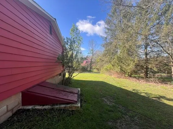 a view of a big yard with a house in the background