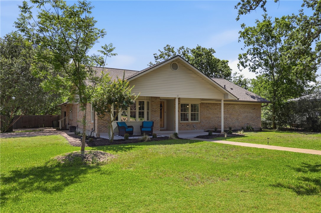 515 Crescent Drive Bryan, TX 77801 - Photo 2 of 43 Brick exterior residence featuring a covered front porch, gabled roofline, and well-maintained lawn