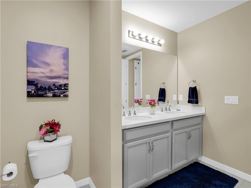 14695 Edgewater Circle Naples, FL 34114 - Photo 21 of 39 a bathroom with a toilet sink and mirror