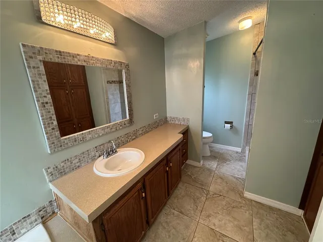 a bathroom with a sink a toilet and mirror