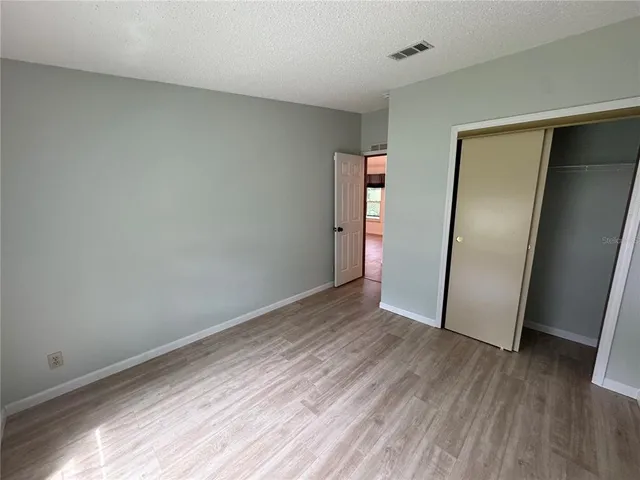 an empty room with wooden floor and closet