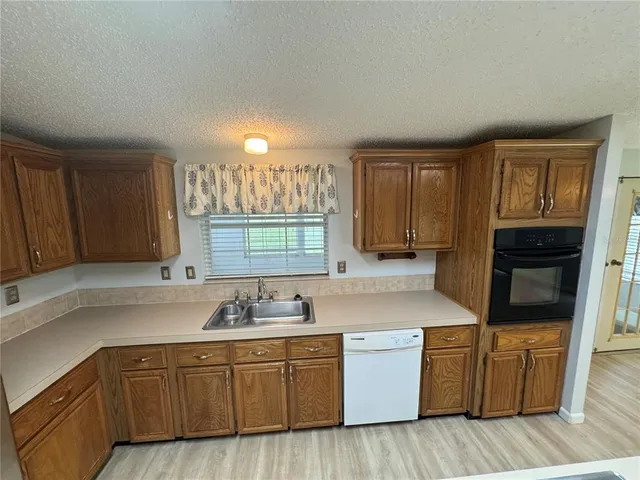 a kitchen with granite countertop cabinets stainless steel appliances a sink and a window