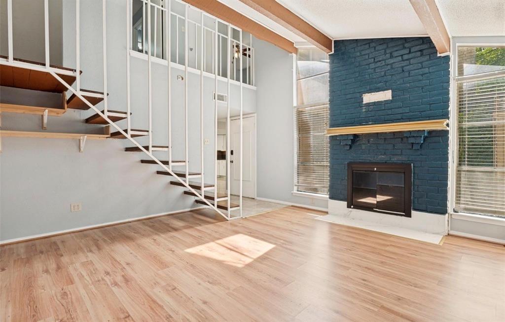 5808 Harvest Hill Road Dallas, TX 75230 - Photo 5 of 18 Living area featuring wood-finish flooring and a fireplace with a blue brick surround and wood mantel