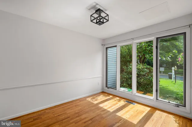 a view of empty room with window and chandelier