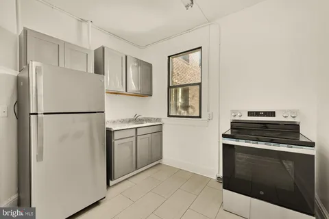 a kitchen with a stove top oven and refrigerator