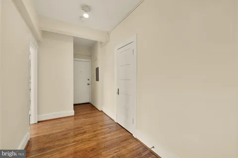 a view of an empty room with wooden floor