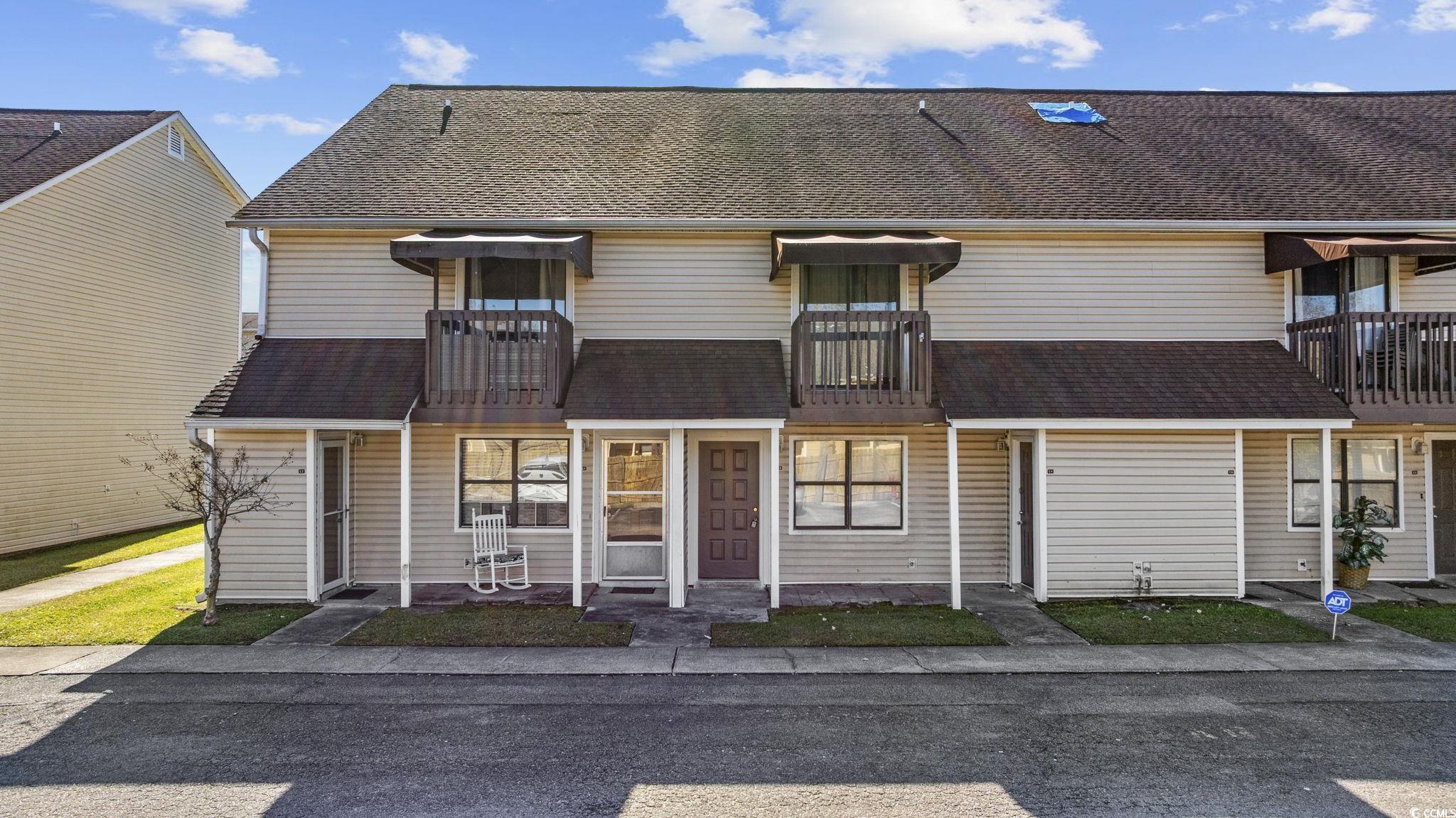 View of front facade with a balcony and roof with shingles