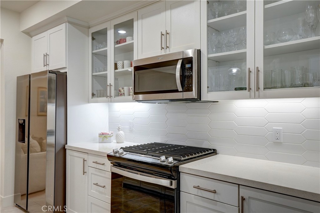 16235 Dawn Way, Unit 203 Tustin, CA 92782 - Photo 16 of 74 a kitchen with stainless steel appliances white cabinets and a stove top oven