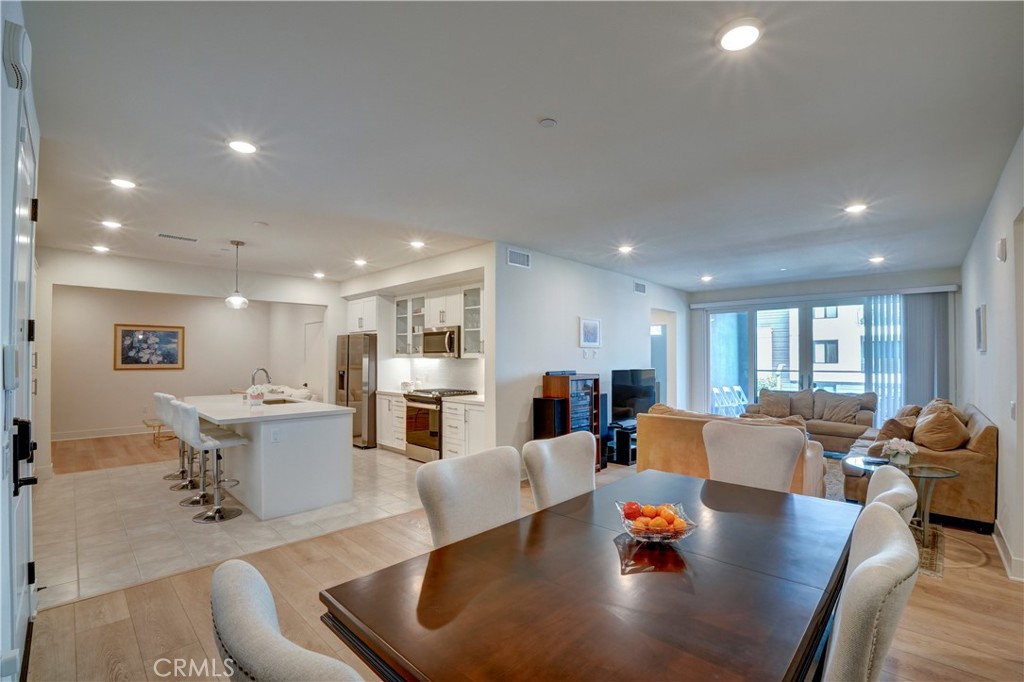 16235 Dawn Way, Unit 203 Tustin, CA 92782 - Photo 23 of 74 a living room with fireplace furniture and a dining table with wooden floor