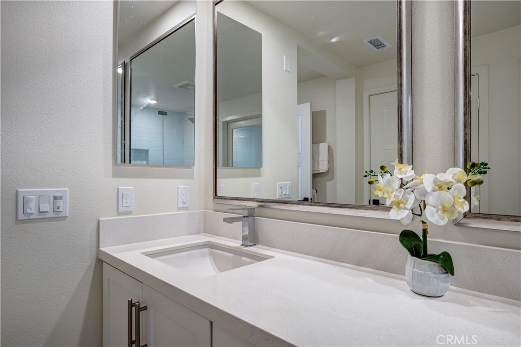 16235 Dawn Way, Unit 203 Tustin, CA 92782 - Photo 50 of 74 a bathroom with a potted plant on the counter and mirror