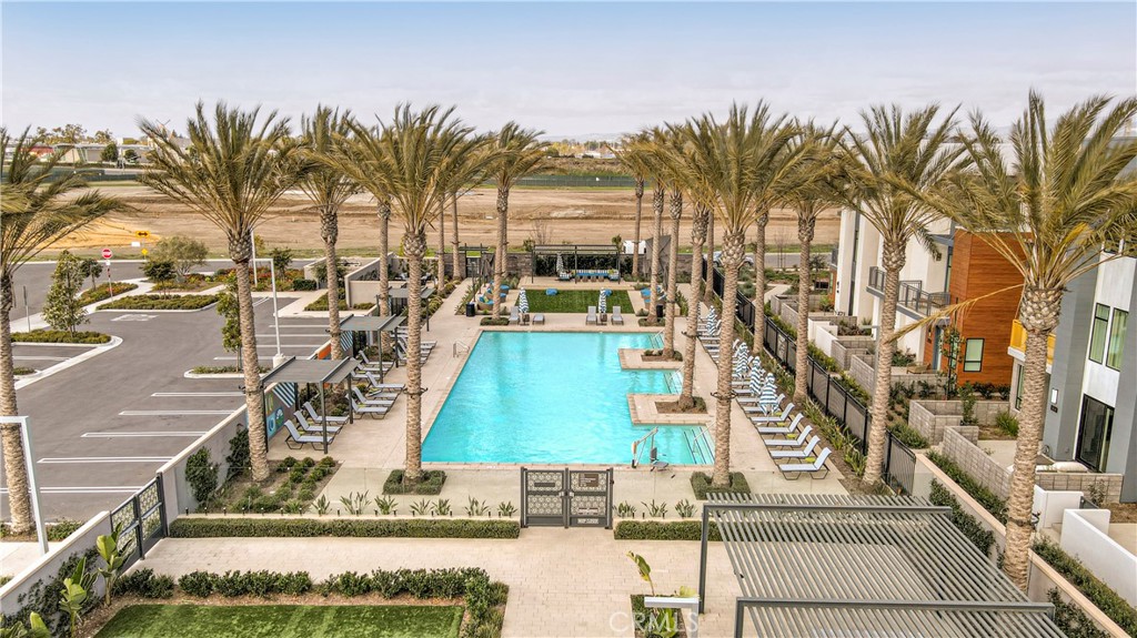 16235 Dawn Way, Unit 203 Tustin, CA 92782 - Photo 61 of 74 a view of a swimming pool with a lawn chairs under palm trees