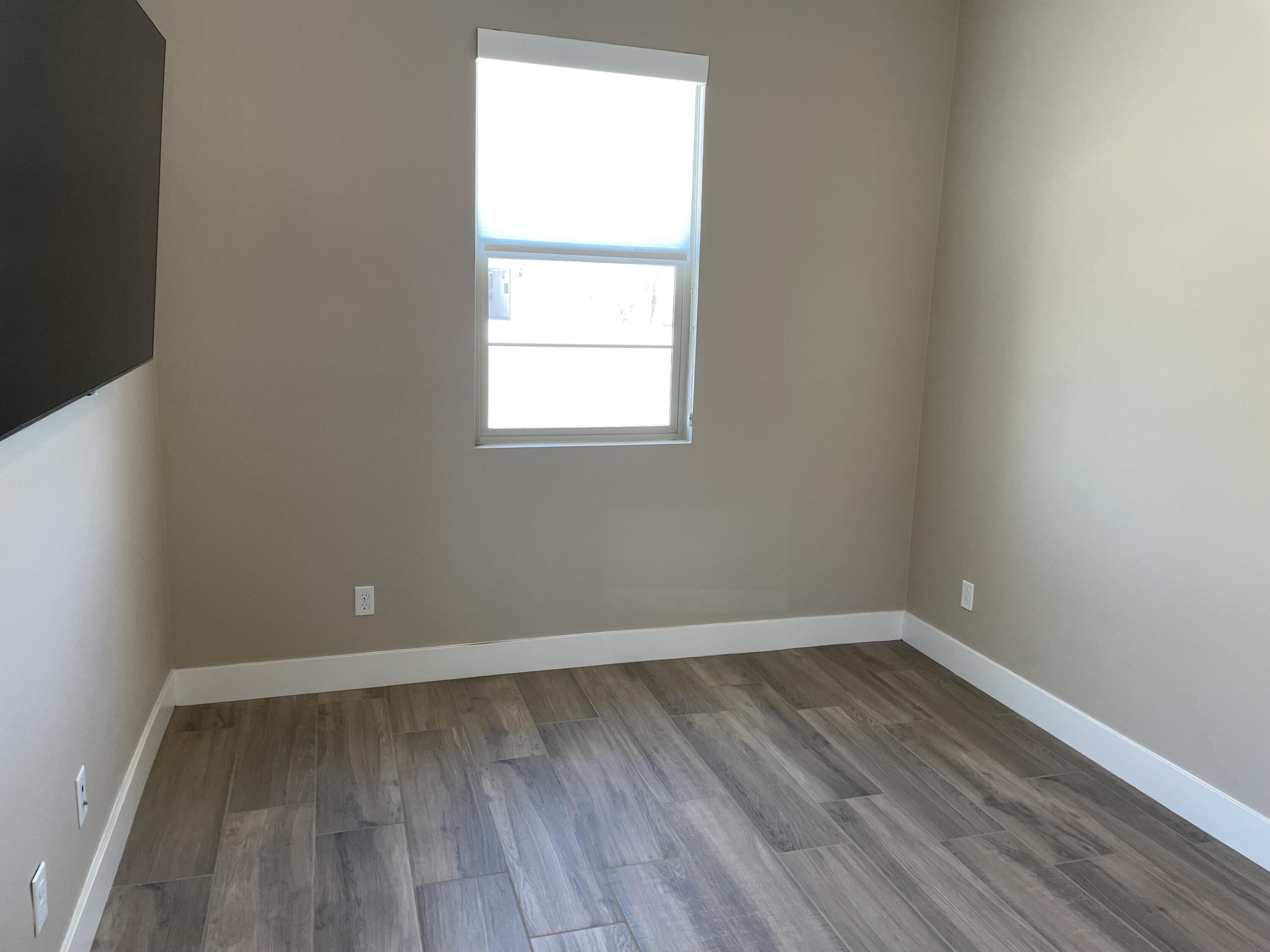 35 Semillon Rancho Mirage, CA 92270 - Photo 6 of 13 an empty room with wooden floor and windows