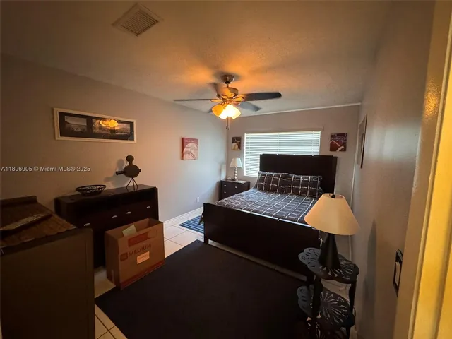 a bedroom with a bed and a lamp on the dresser