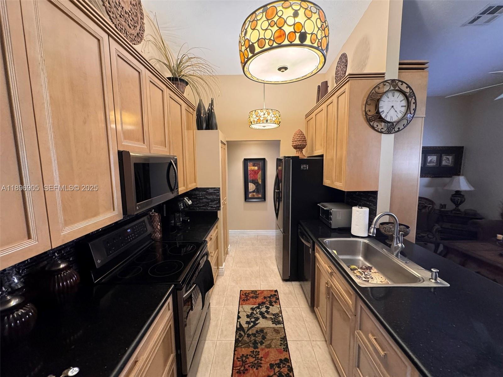 705 Southeast 3rd Lane Dania Beach, FL 33004 - Photo 4 of 15 a kitchen with stainless steel appliances granite countertop a stove and a microwave