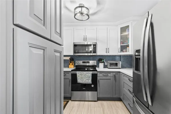 a kitchen with stainless steel appliances granite countertop a stove a refrigerator and a microwave