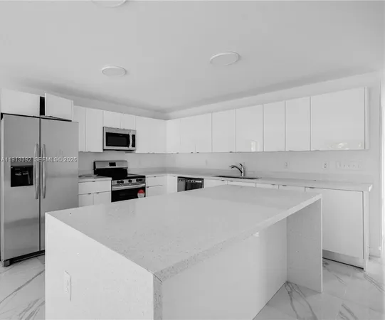 a kitchen with stainless steel appliances a refrigerator sink and microwave